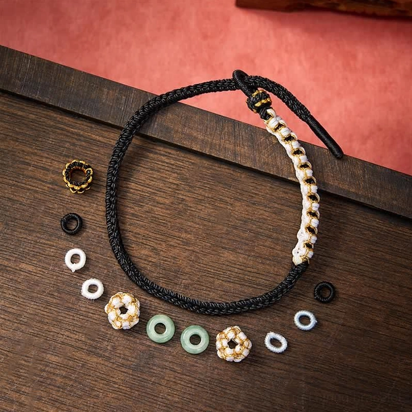 Black string bracelet flat lay with replacement beads and decorative parts