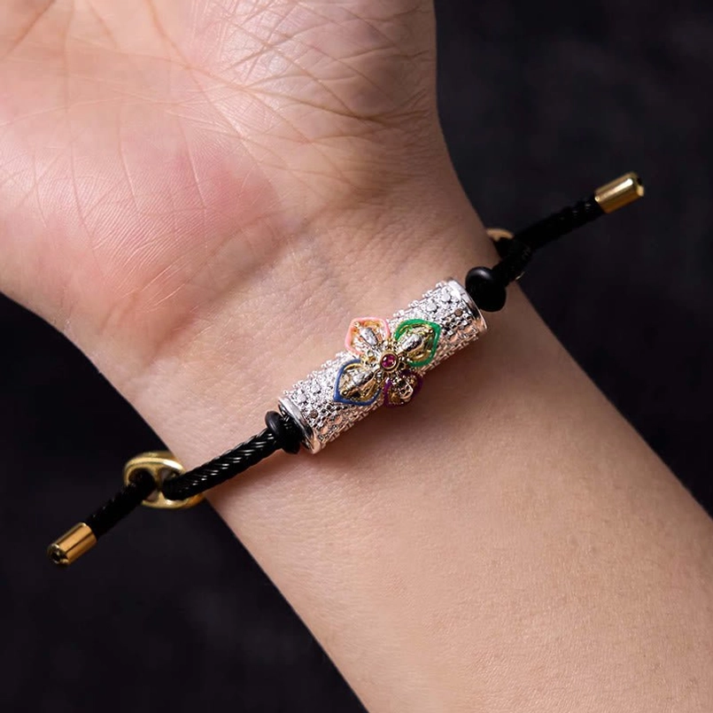 Black string bracelet variant with colorful enamel flower design and metal accents