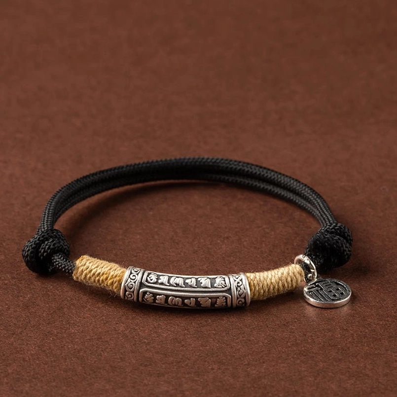 black rope tibetan mantra bracelet with silver fu character pendant flat lay