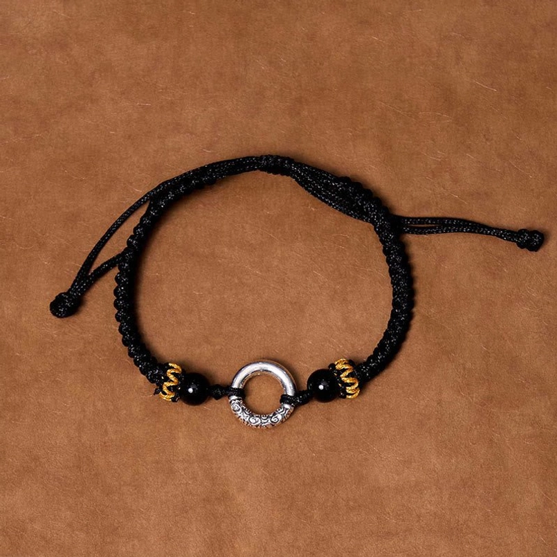 Black peace buckle protection bracelet worn on wrist showing adjustable fit