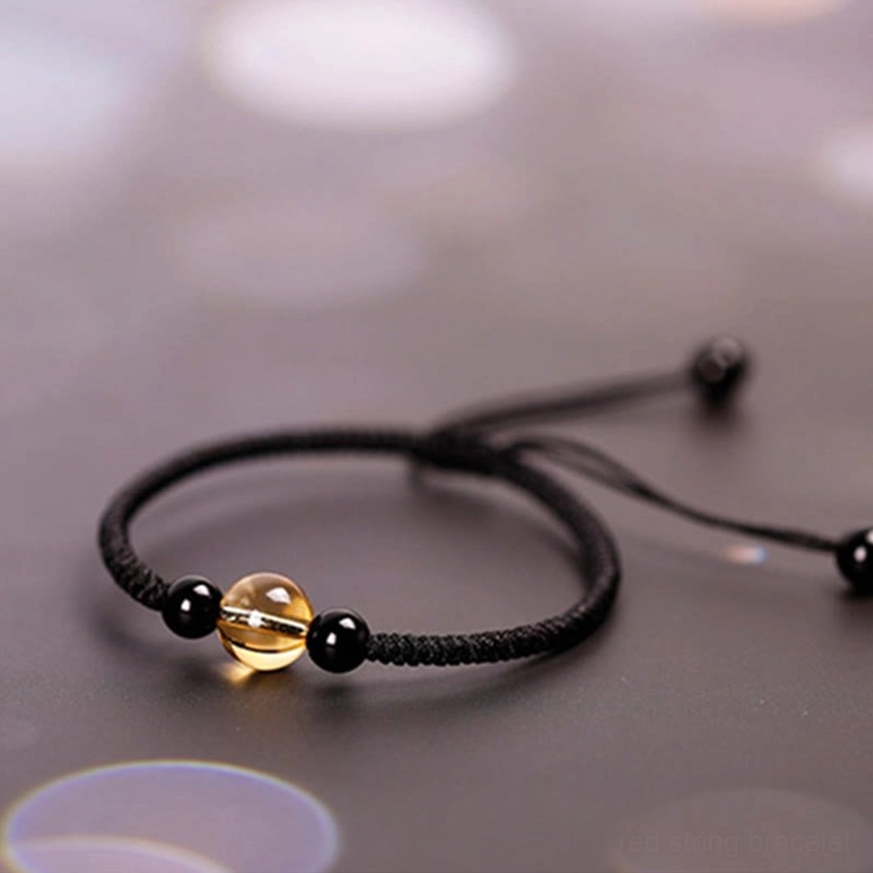 Black cord luck bracelet top down view with adjustable pull knots