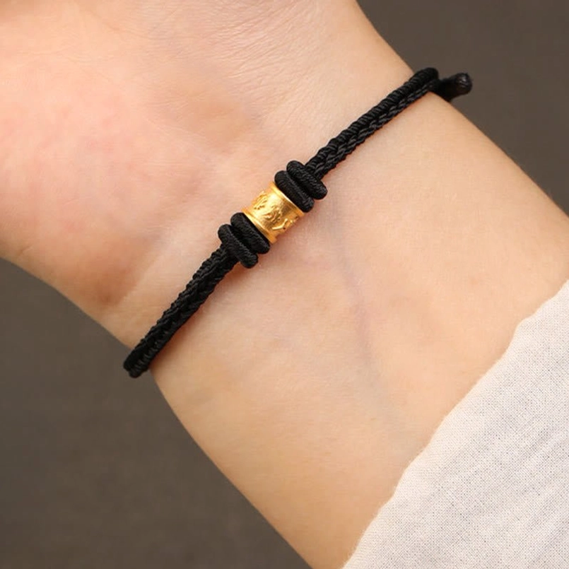 Real wearing shot of black string Tibetan 999 gold luck protection bracelet on wrist