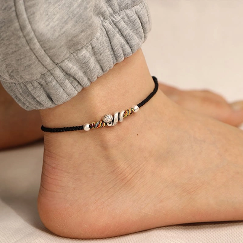 Black string Year of the Snake anklet with 999 sterling silver snake charm providing spiritual protection and grounding energy