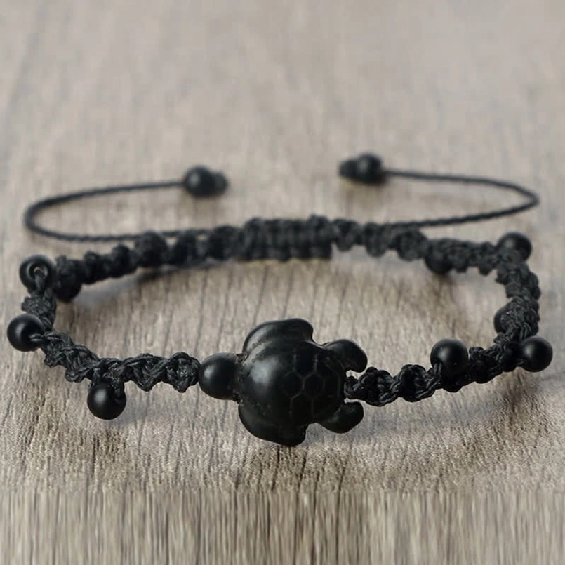 Black turtle braided cord bracelet on wooden table