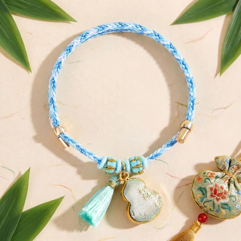 Blue five color song brocade lucky bracelet with mint tassel and embroidered gourd pendant on beige background