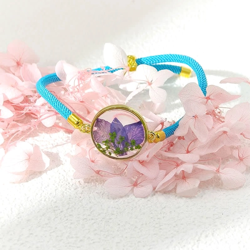 Blue braided rope birth flower bracelet with purple spiked pressed flower resin charm