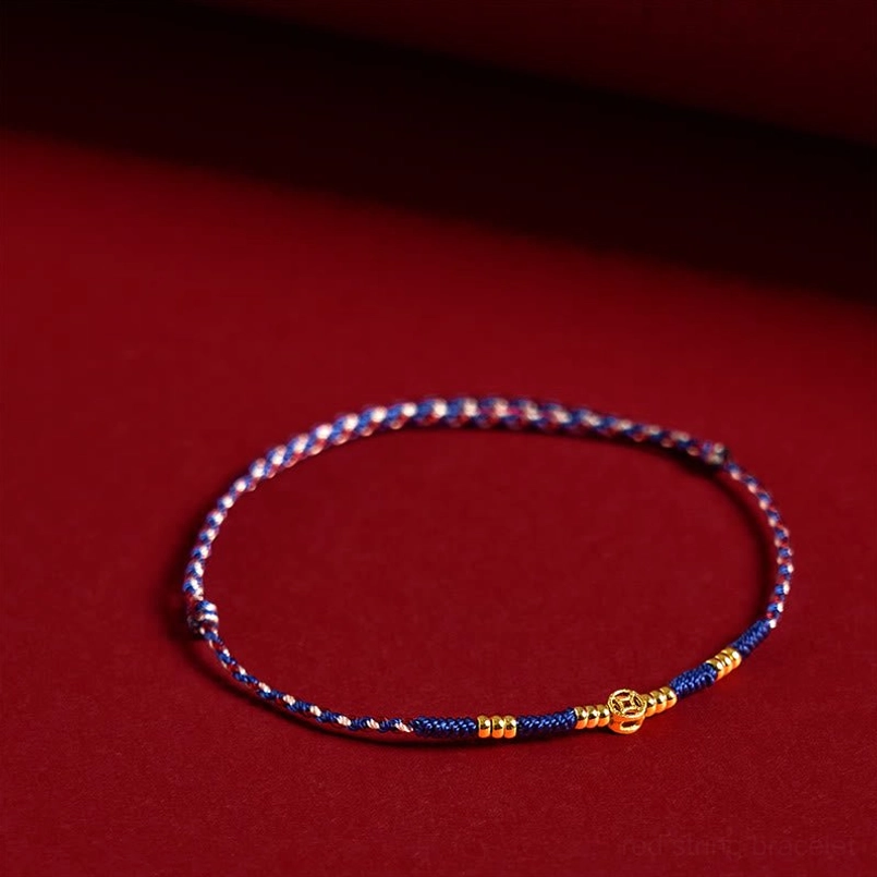 Blue braided luck bracelet with gold charms and copper details, side oblique view