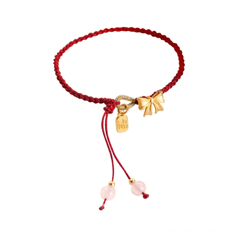 Red string Fu bracelet with gold bow knot charm and pink bead adjustable tassel on white background