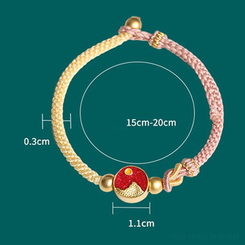 Close-up detail shot showing woven rope texture, gold copper beads and red enamel mountain-sea charm