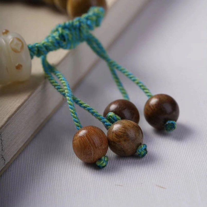 Turquoise tassel cord detail with wooden beads on sandalwood bracelet