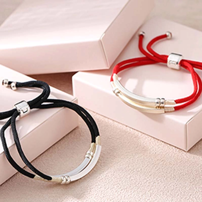 Three Sterling Silver Red String Braided Bracelets stacked on luxury pink gift packaging
