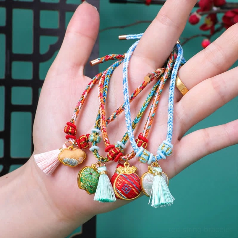 Hand-held five-color braided red string bracelets with various enamel and embroidered charms on wrist