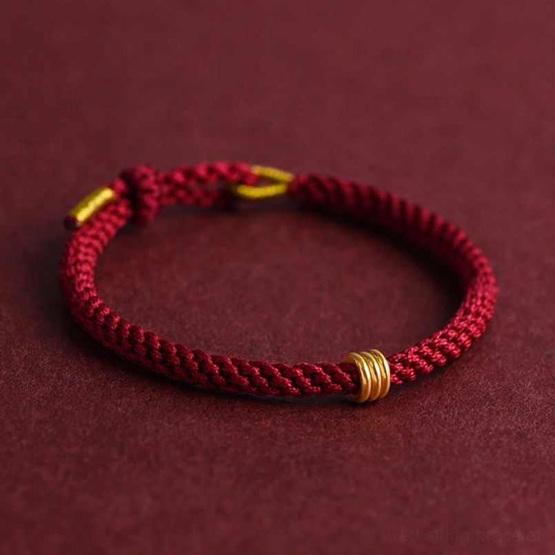 Red string braided bracelet with polished gold ring detail side view luxury