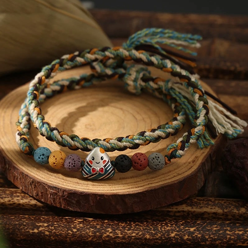 Close up of braided rice dumpling theme luck bracelet on wooden surface
