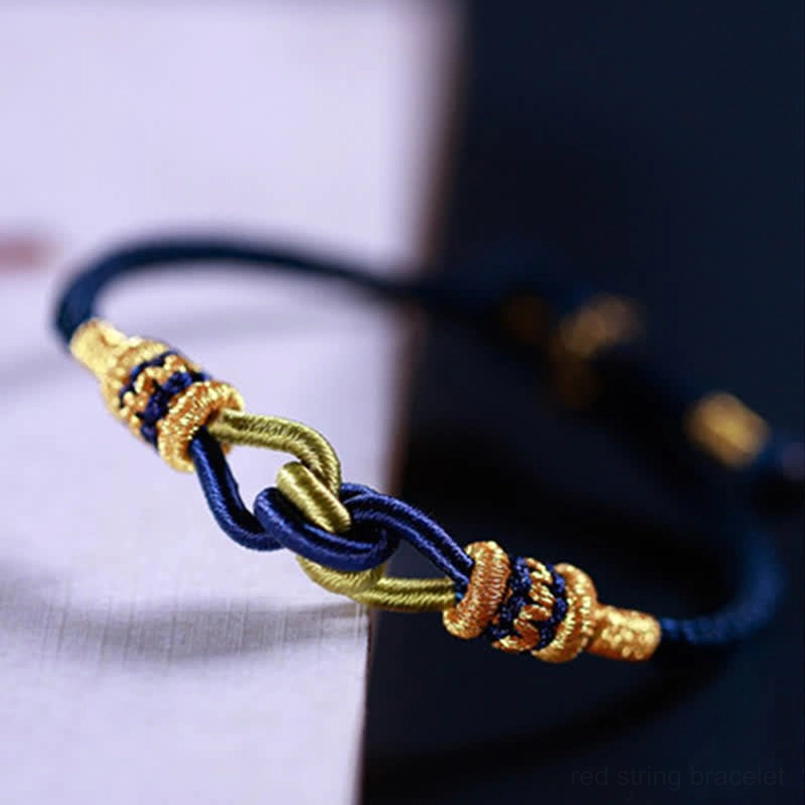 Braided string bracelet close up view navy blue gold green twisted knots