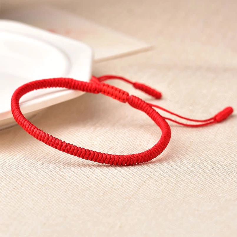Bright crimson red woven bracelet with flat braided pattern and pull-tie adjustment