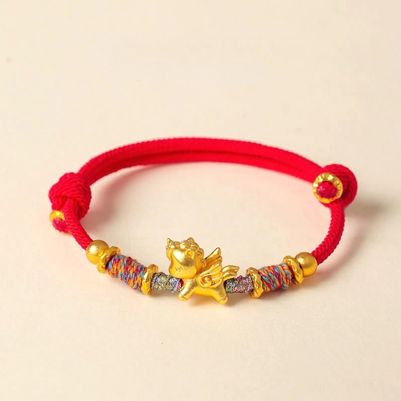 Bright red braided string bracelet with gold plated horse charm flat lay