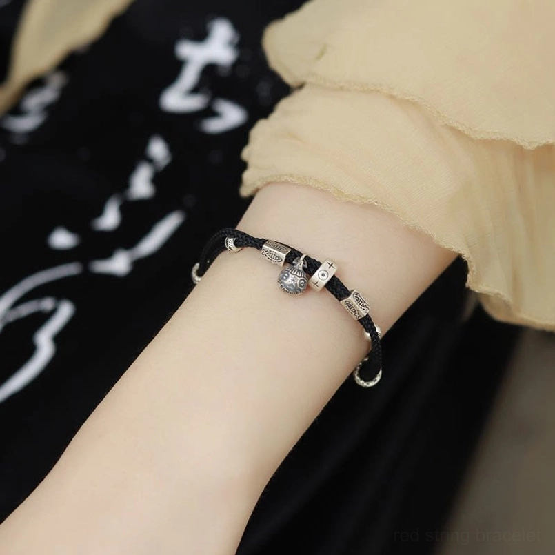 Brown braided prosperity bracelet with large bell pendant detail