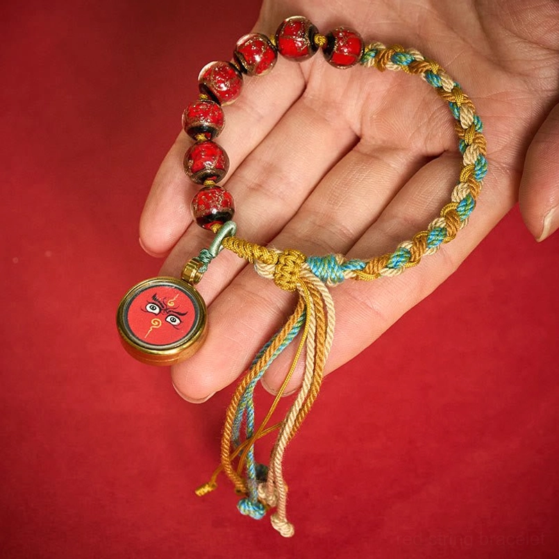 Tibetan liuli glass bead Buddha eye bracelet side profile on wooden surface