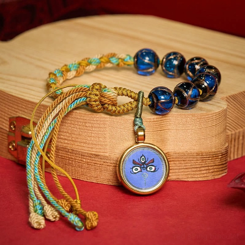 Five Directions Wealth God bracelet with detailed Buddha eye pendant on wooden display
