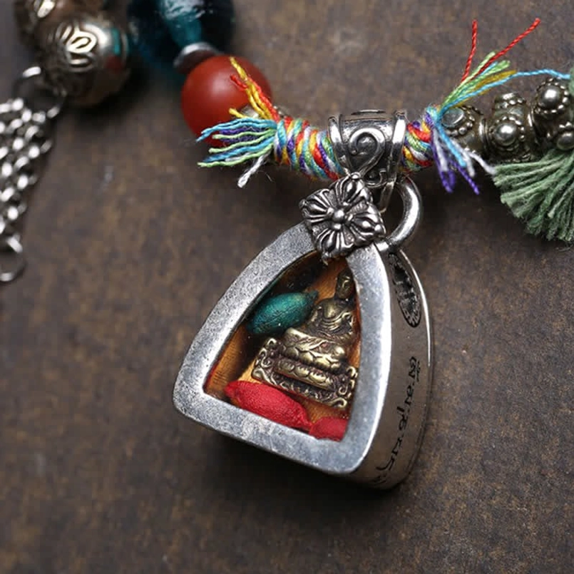 Silver triangle Buddha pendant with colorful tassels and metal flower charm detail