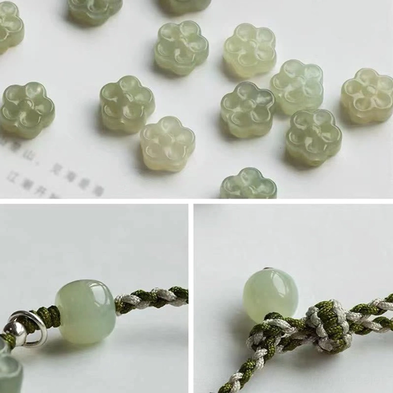 Close-up of carved jade plum blossom beads with smooth polished finish celadon color