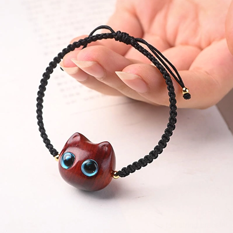 Woven black cord cat head bracelet with gold metal beads side view