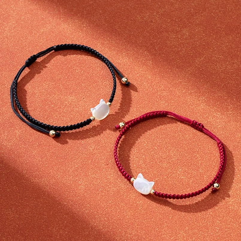 Cat charm shell bracelets set red and black string options overhead view