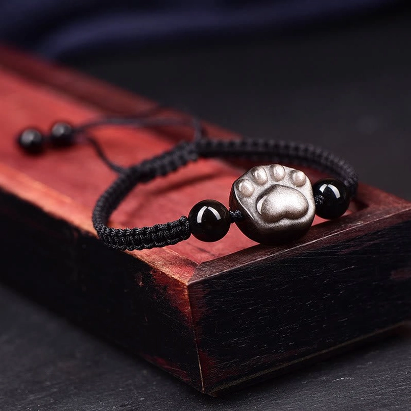 Cat paw obsidian black string bracelet on wooden box arrangement