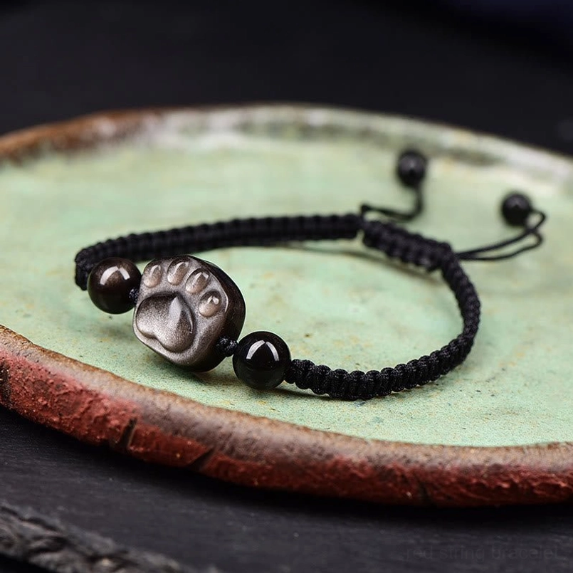 Cat paw obsidian bracelet black rope on celadon ceramic plate