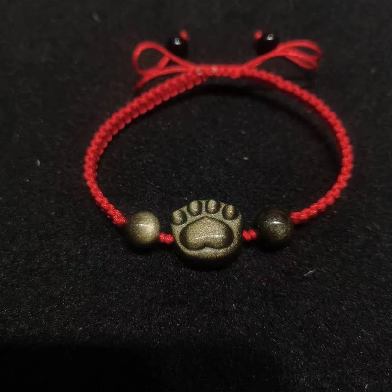 Cat paw obsidian red rope bracelet bronze charm black background