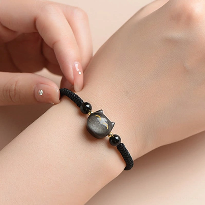 Silver Sheen Obsidian cat protection bracelet worn on wrist, showing fit and cat charm with gold details