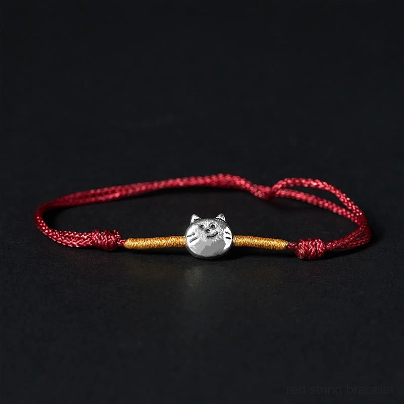 925 sterling silver cat charm red string bracelet with gold accents on black background