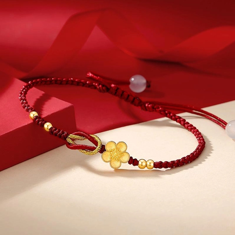 Cherry blossom charm red string bracelet flat lay side view red gift box backdrop
