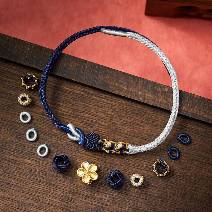 Two-tone bracelet with navy rope, silver accents, and mixed loose beads on dark wooden desktop