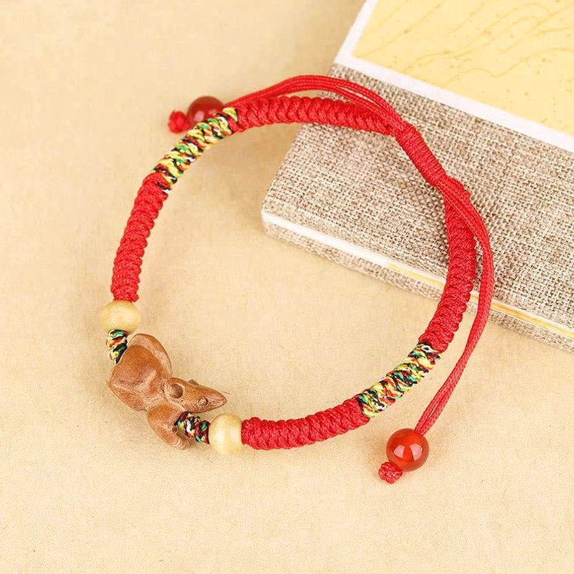 Chinese zodiac red string bracelet lifestyle shot wooden table