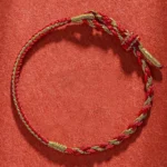 Red and gold twisted Chinese zodiac protection bracelet flat lay with adjustable knot