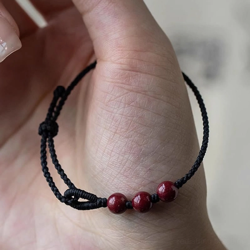 Cinnabar bead black string bracelet worn on real human wrist