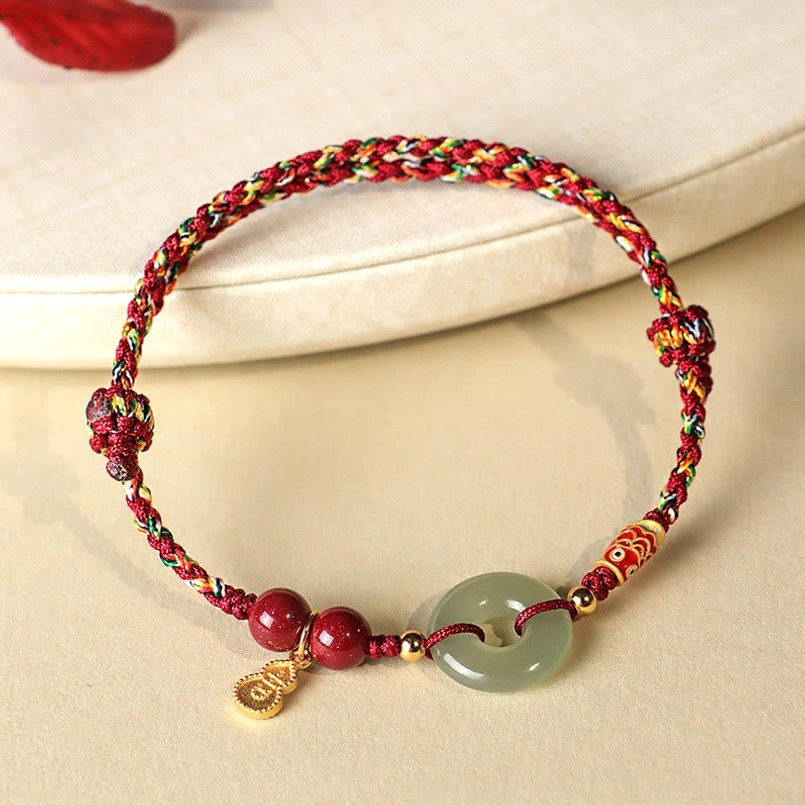 Natural cinnabar bead close up on red string protection bracelet