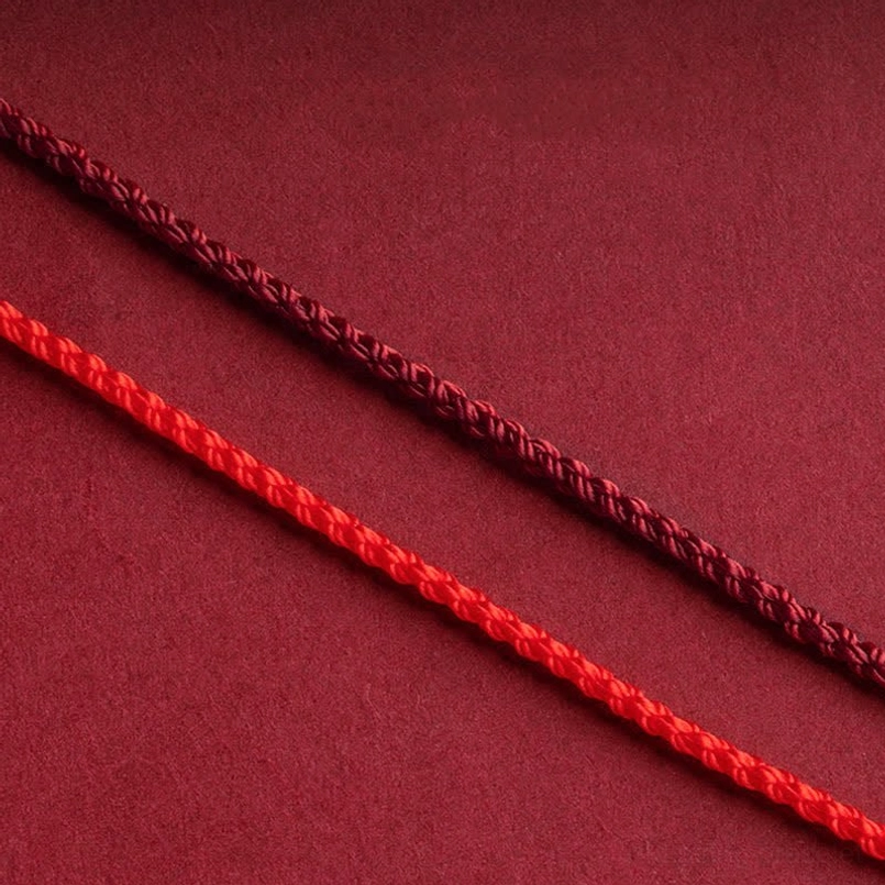 Cinnabar beads and gold infinity charm close-up showing natural material quality and texture