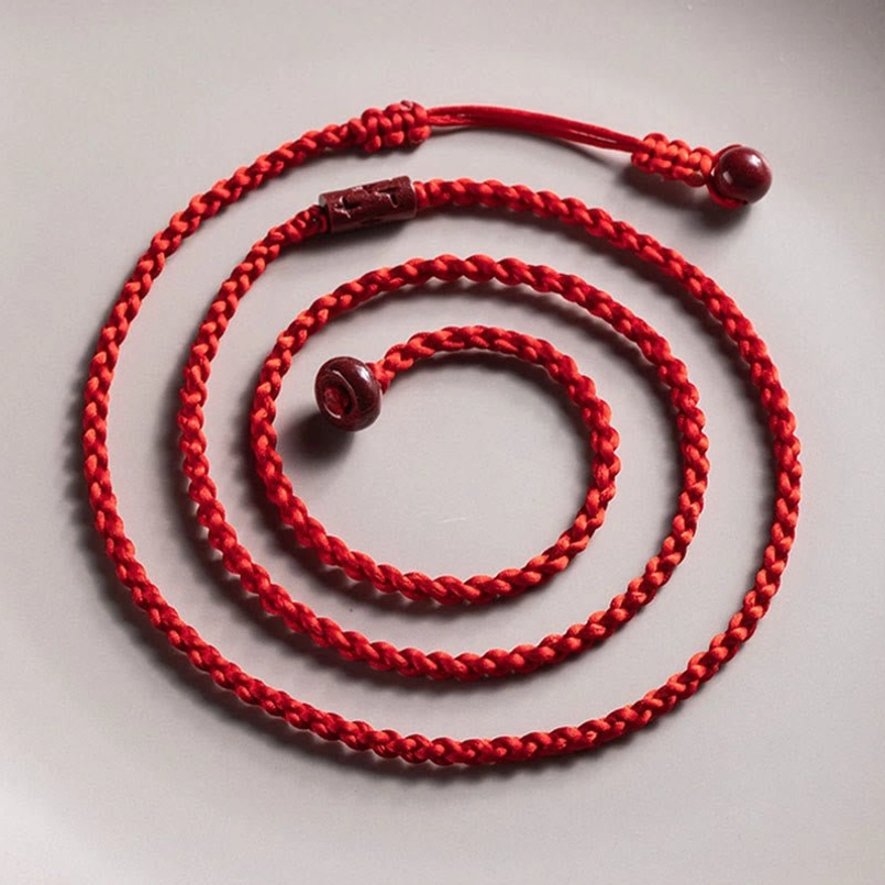 Multi-layer coiled cinnabar belly chain with dual cinnabar bead ends and decorative beads on light gray background