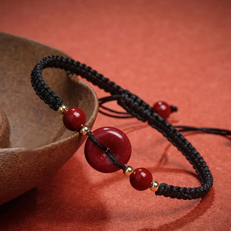 Black braided cinnabar blessing bracelet with tassel and bead accents
