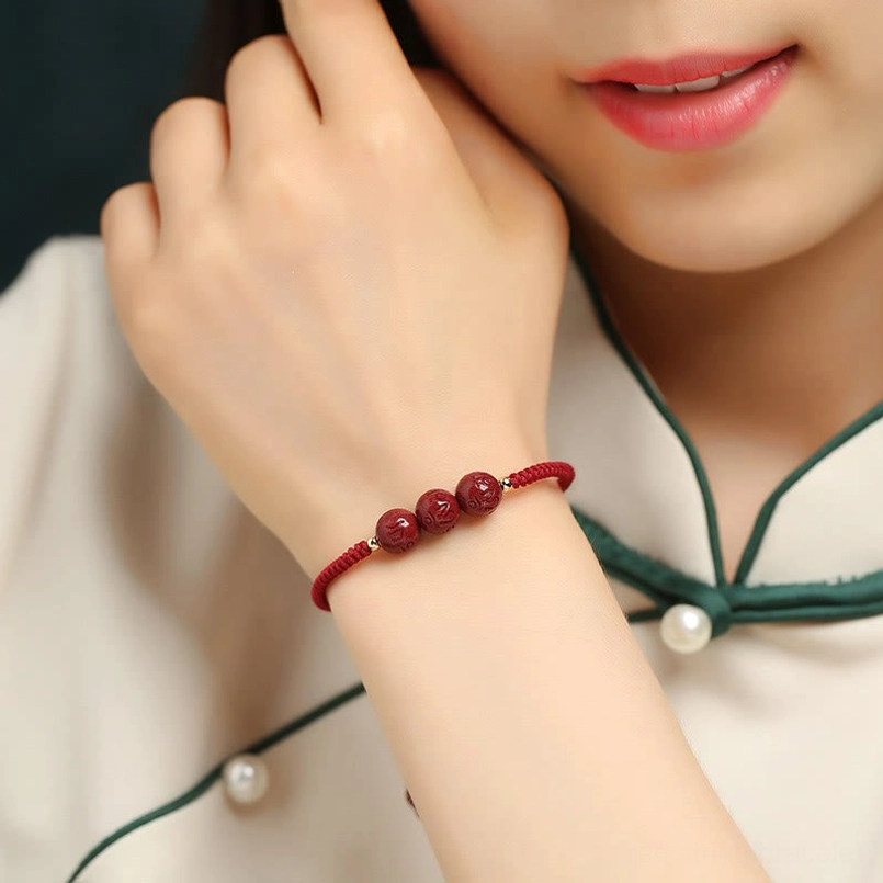 Handmade cinnabar mantra bracelet worn on wrist with traditional cheongsam