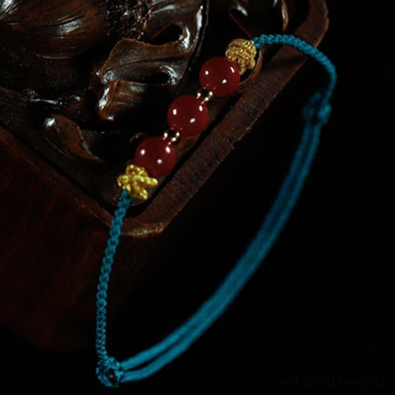 Cinnabar bracelet placed on dark wooden box side top view