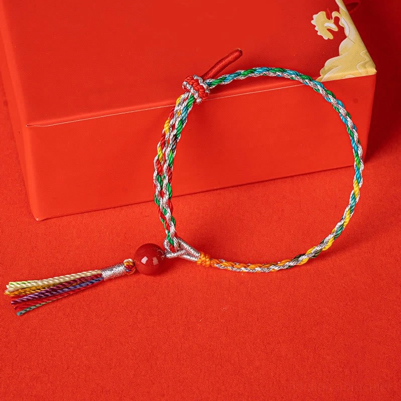 Flat laid colorful cinnabar string bracelet with tassel detail
