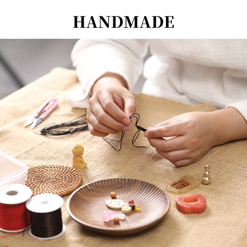 Putting on red string cinnabar bracelet showing gold decorative buckle fastening