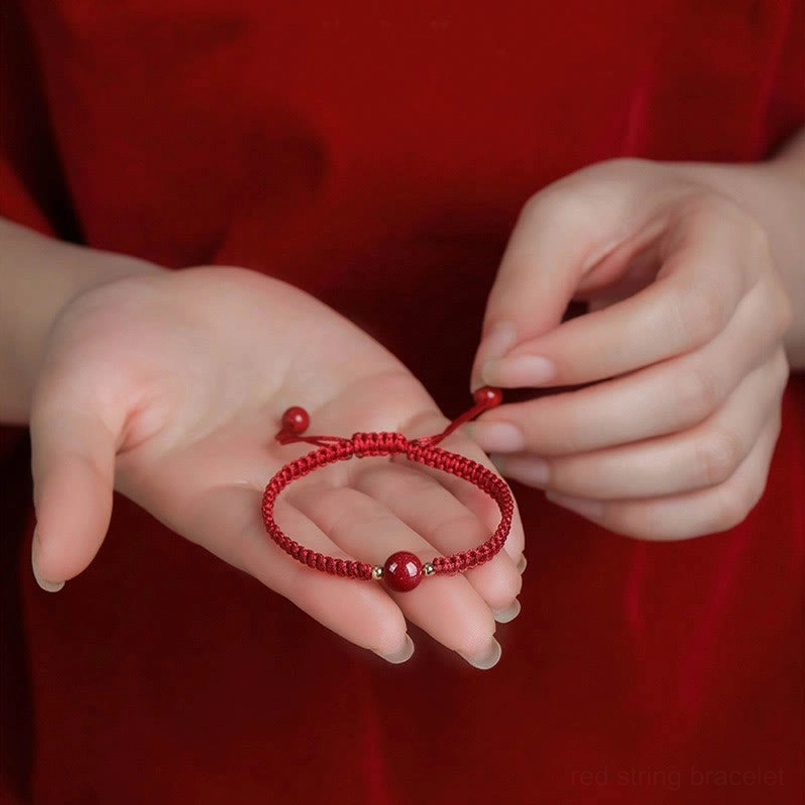 Adjustable cinnabar bracelet on hands showing hand-knotted sliding knot closure