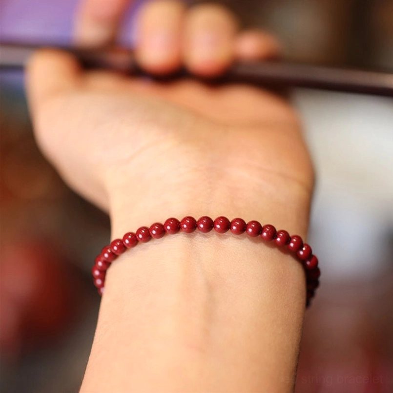 Close-up side view of cinnabar red string bracelet on wrist demonstrating perfect fit