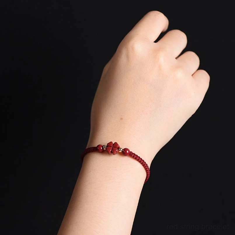 Cinnabar flower charm red string bracelet worn on left wrist