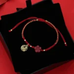 Cinnabar Fu character red string bracelet flat lay with adjustable drawstring closure
